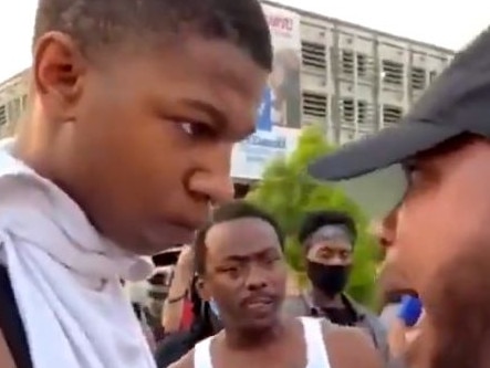 A teenage boy listens to an older man talk about the protests. Picture: Twitter