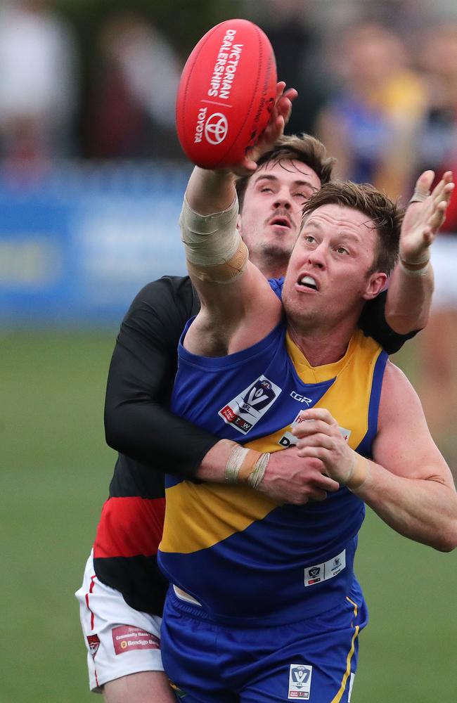 Nick Meese beats Essendon’s Michael Hartley to a tap.