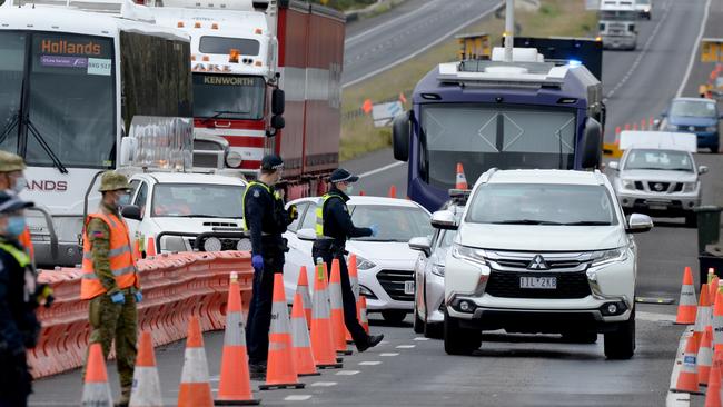 Police and ADF personnel at a checkpoint heading out of Melbourne. Picture: Andrew Henshaw