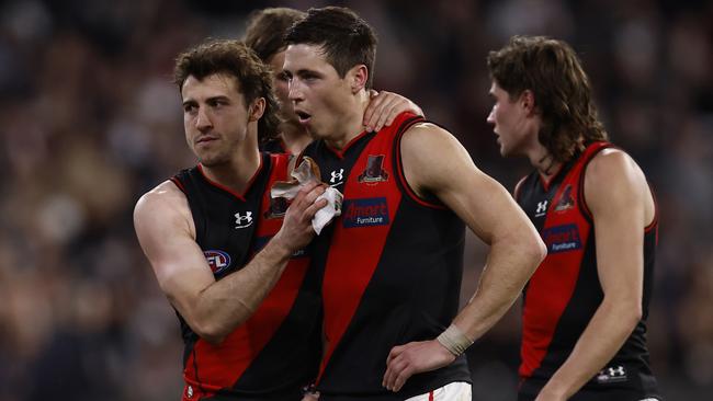 Andy McGrath and dejected Essendon players walk from the ground (Photo by Darrian Traynor/Getty Images)