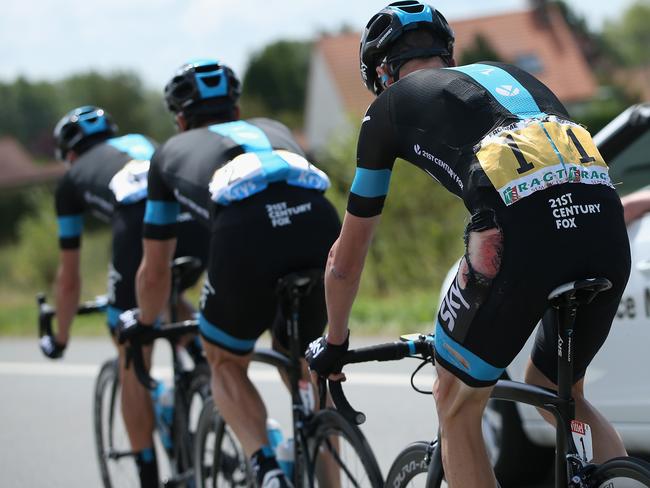 Chris Froome of Team Sky follows the wheels of his teammates Bernhard Eisel and David Lopez Garcia as they chase back to the peloton after Froome’s crash.