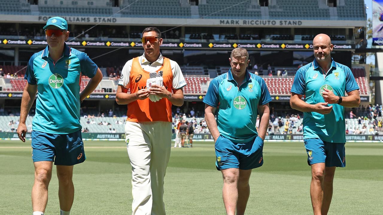 Australian coach Andrew McDonald, Scott Boland and Crows coaches Scott Burns and Matthew Nicks exit the field during the tea break. Picture: Paul Kane/Getty Images