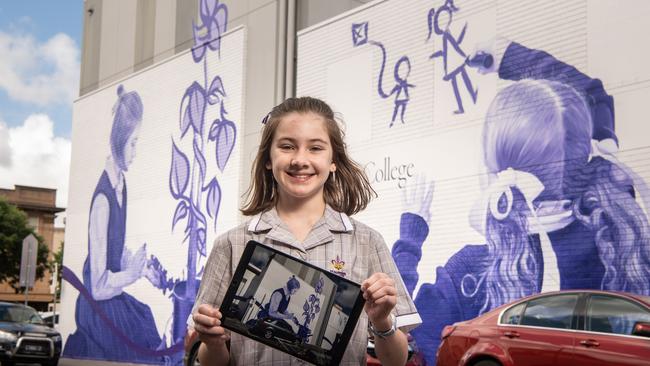 St Aloysius College student Celeste Owens, 11, in front of the school’s new interactive mural. Picture: Brad Fleet