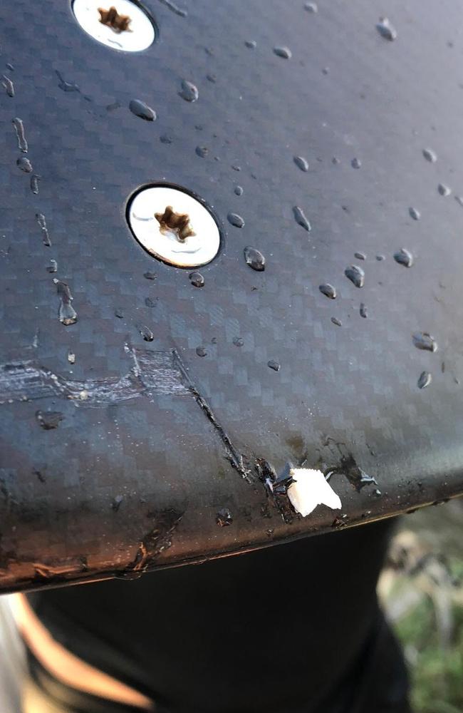 Linda Marchant Sinclair shows the bite marks and tooth left behind by a shark that attacked the foil surfboard.