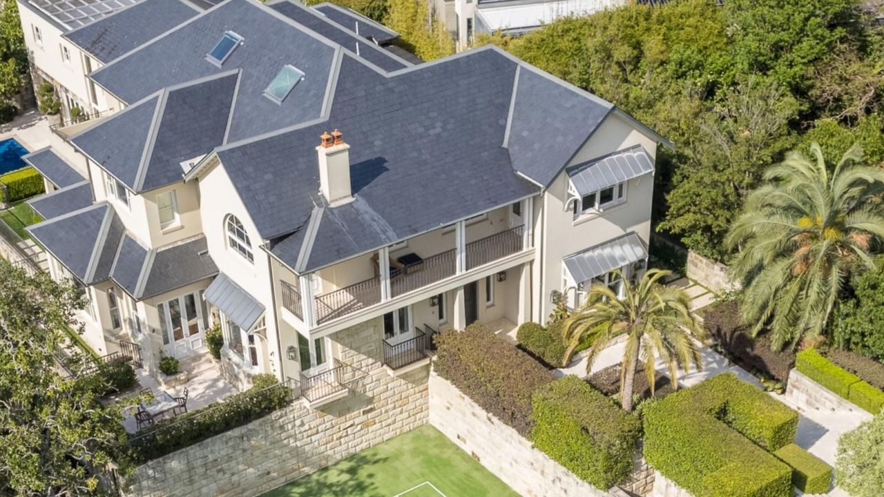 An aerial view of the grand home, which features a pool and a tennis court.