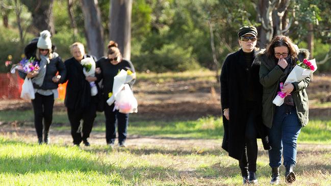 Courtney’s mother (right) walks to lay flowers at the logs where her body was found. Picture: Sarah Matray