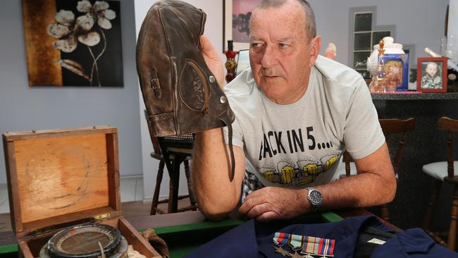 Craig Tonkin with his father's WWII helmet and other wartime mementos at his Burleigh Waters home. Picture: Mike Batterham