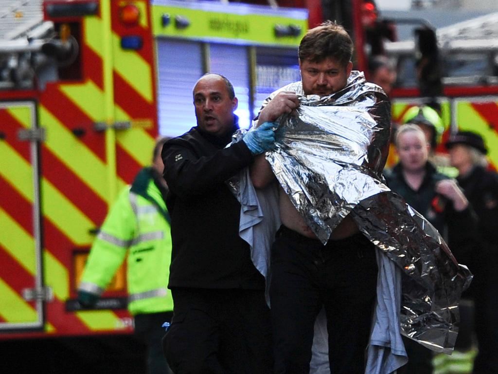 Police assist an injured man near London Bridge. Picture: DANIEL SORABJI / AFP.