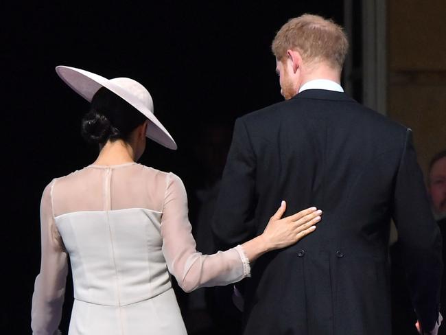 Meghan places a protective hand on Harry’s back. Picture: Dominic Lipinski