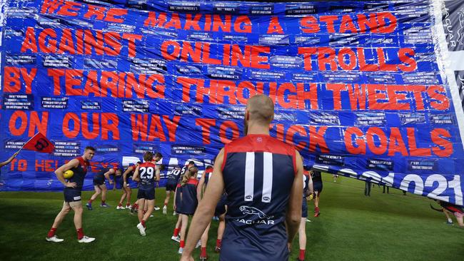 Max Gawn runs through the Demons banner taking a stand against online bullies. Picture: Michael Klein