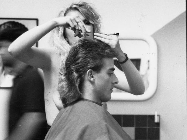 Romano Ticconi, 25, has his hair trimmed by topless hairdresser Michelle in an Adelaide hair salon, May 1991.