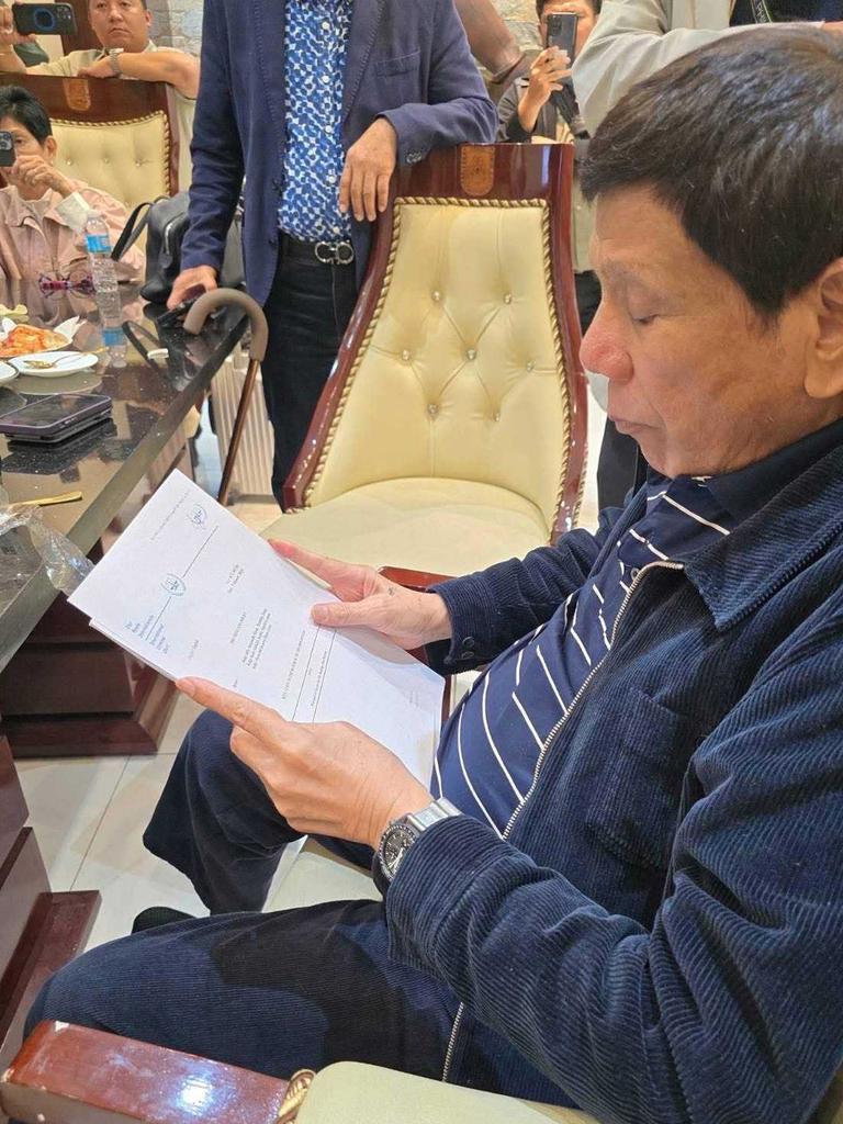 Former president Rodrigo Duterte sits at a table in custody at Villamor Air Base in Manilaon March 11, 2025 in Manila, Philippines after being arrested on an International Criminal Court warrant for crimes against humanity linked to thousands of deaths over his brutal anti-drug campaign. His arrest follows an extensive international investigation into these killings. (Handout photo by Senator Christopher Go via Getty Images)