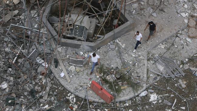 Men walk through a debris-covered street in Beirut. Picture: Marwan Tahtah/Getty