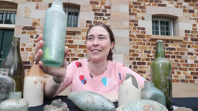 Urbis archaeologist Holly Maclean examining some of Brisbane’s oldest European artefacts. Picture: Annette Dew