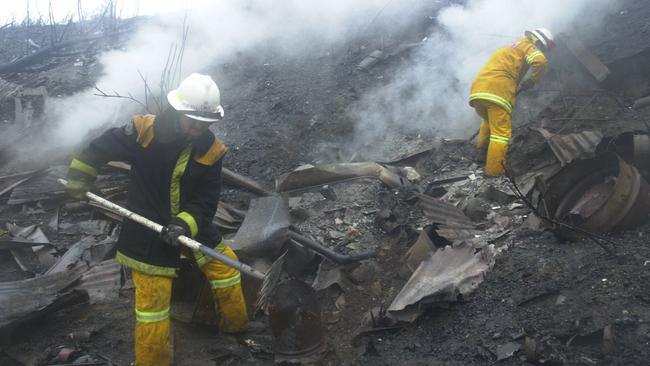 No rest for the wicked... Firefighters mop up in the rain earlier this month after bushfires swept through Medlow Bath. Picture: Renee Nowytarger