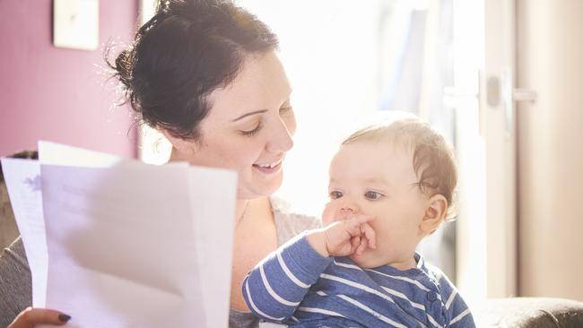 A young mother reads through a legal pack from her insurance company or solicitor. She is making provisions for the future of her child. life insurance generic, family protection