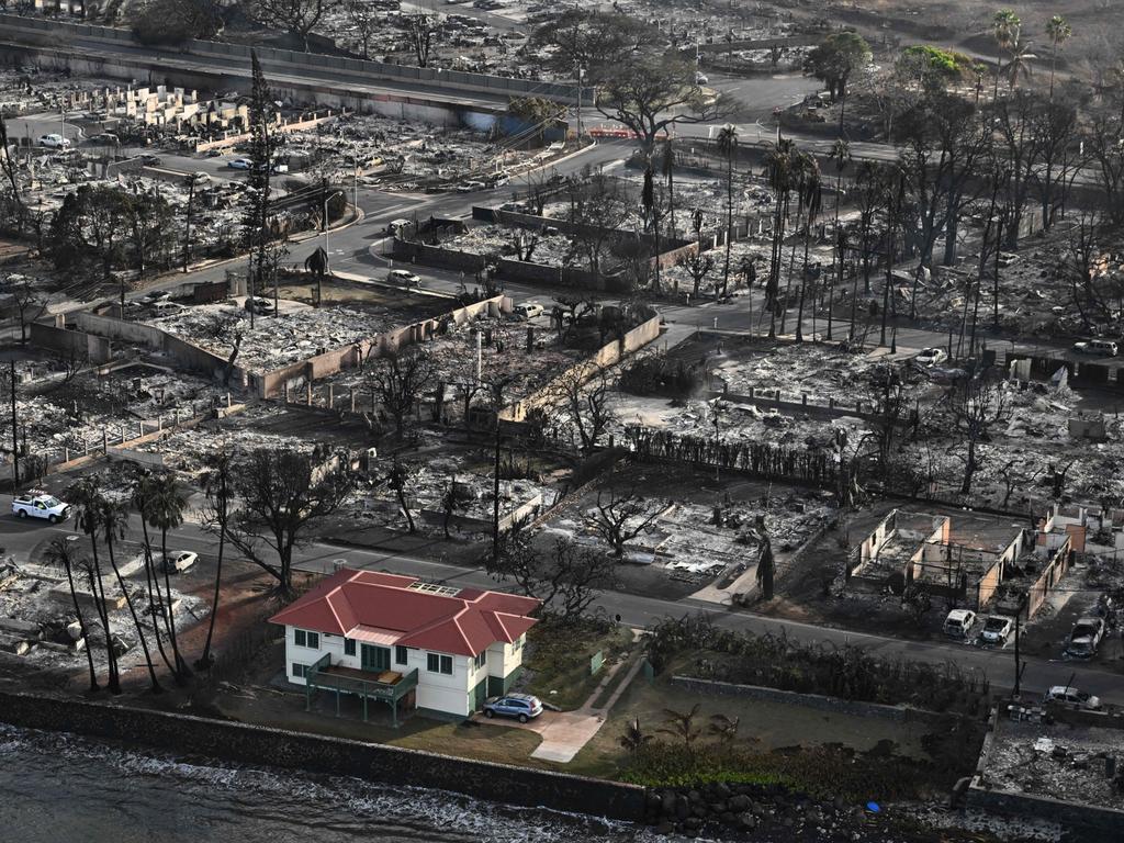 An aerial shot of a red roofed house incredibly surrounded by destroyed homes and buildings burned to the ground in Lahaina, Maui in the aftermath of wildfires in Hawaii in August. Picture: Patrick T. Fallon/AFP