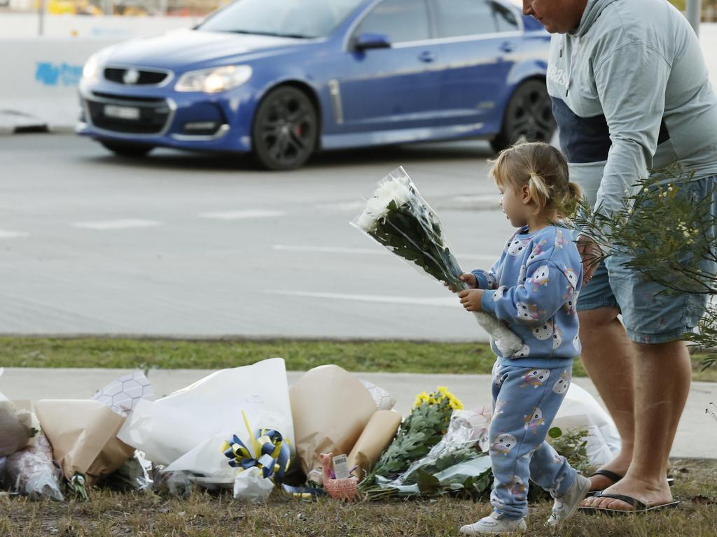 People leaving floral tributes near the scene of the horrific bus crash. Picture: Jonathan Ng