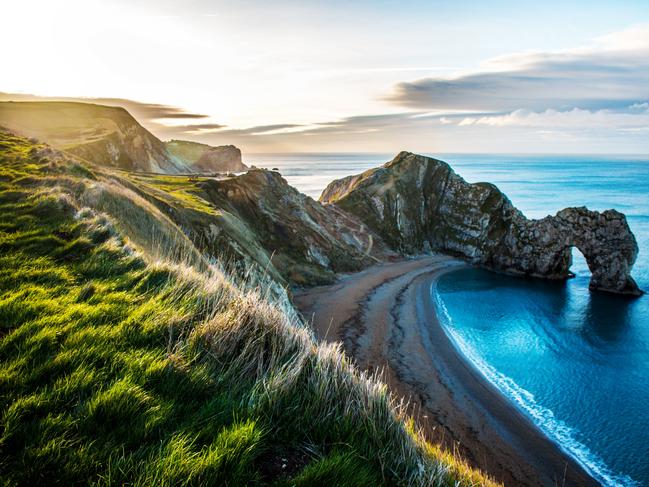 ESCAPE: Dorset by Kerry Parnell - Durdle Door beautiful Dorset beach.Durdle Door Cove, Dorset. View of Rock formation Durdle Door on the Dorset Coast. Sail boat passing the eye of Durdle's Door. Dorset beach, blue sky at Durdle Door Lulworth  Picture: Istock