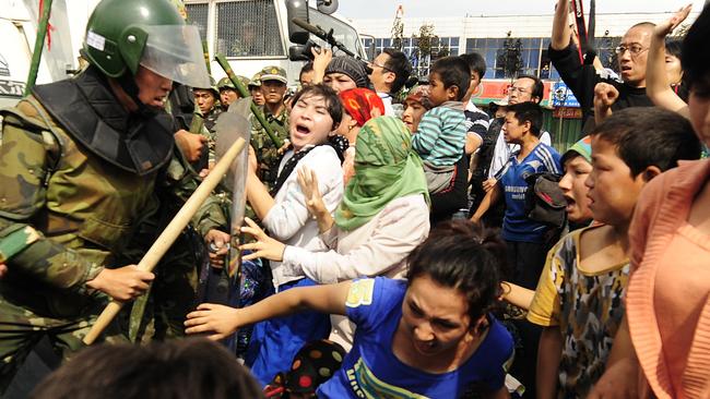 Ethnic Uygur women clash with Chinese riot police as they protest in Urumqi in China's far west Xinjiang province on July 7, 2009. Police fired clouds of acrid tear gas to disperse thousands of Han Chinese protesters armed with makeshift weapons. Picture: AFP/Peter Parks