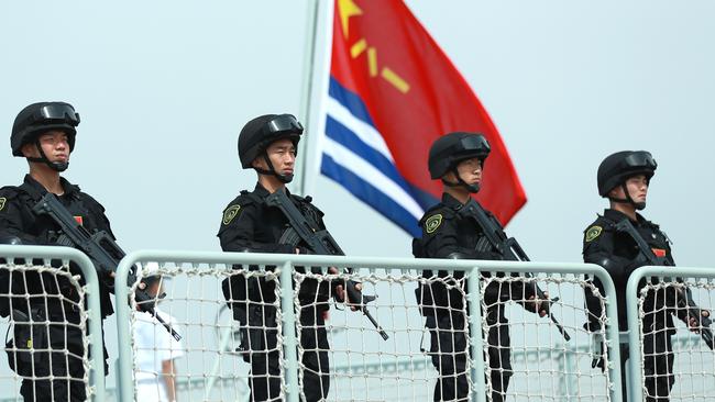 Members of the Chines Navy stand on the deck of a navy ship at a military port in Zhoushan, Zhejiang Province of China. Picture: Getty Images.