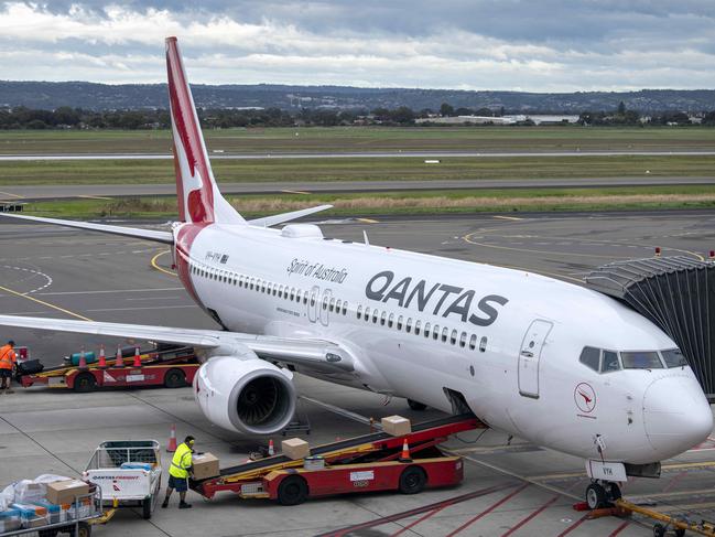 ADELAIDE, AUSTRALIA - NewsWire Photos August 10, 2022: Baggage handlers load luggage on a Qantas aircraft at Adelaide Airport.Qantas will increase the waiting time between domestic to international connecting flights by 30 minutes in an effort to mitigate the number of people arriving at their destination without their luggage and has asked executives to work as baggage handlers for three months. Picture: NCA NewsWire