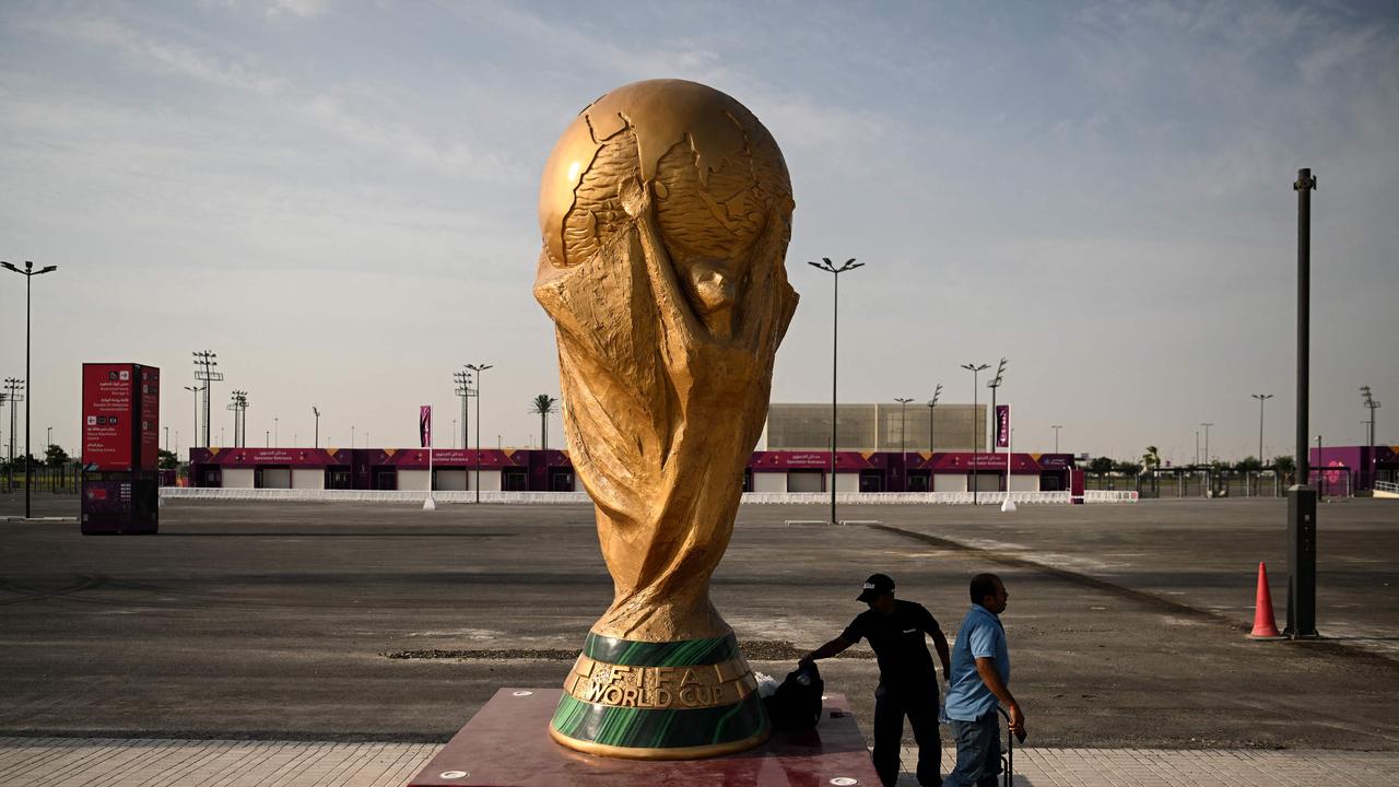 Men walk past a FIFA World Cup trophy replica outside the Ahmed bin Ali Stadium in Al-Rayyan on November 12, 2022, ahead of the Qatar 2022 FIFA World Cup football tournament. Picture: Kirill Kudryavtsev / AFP