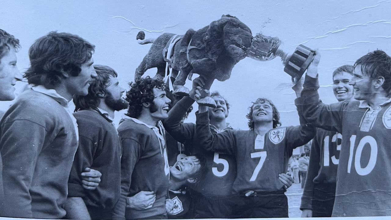 Under the team mascot and the TRL premiership trophy in 1973 are (from left) Ray Prouten, Frank Hedge, Brian Meara, Doug Muir, Graeme Wockner (looking up ground level), Trevor Smith (No. 5), captain Graham Tucker, Gary (Barney) Meara and Trevor Barron.