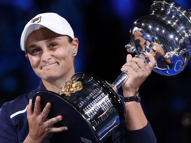 (FILES) This file photo taken on January 29, 2022 shows Australia's Ashleigh Barty posing with the trophy after victory her women's singles final match against Danielle Collins of the US on day 13 of the Australian Open tennis tournament in Melbourne. - Three-time Grand Slam winner and world number one Ashleigh Barty stunned the tennis world on March 23, 2022 by announcing her early retirement from the sport at the age of just 25. (Photo by Aaron FRANCIS / AFP) / -- IMAGE RESTRICTED TO EDITORIAL USE - STRICTLY NO COMMERCIAL USE --