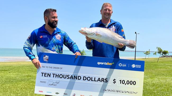 Andrew Russell caught a $10,000 fish at Woods Inlet, five kilometres away from where it was released at Cullen Bay, as part of the Million Dollar Fish season nine. Here he is pictured with Sportsbet NT Operations and Partnerships Manager Thijs Bors (left). Picture: Supplied