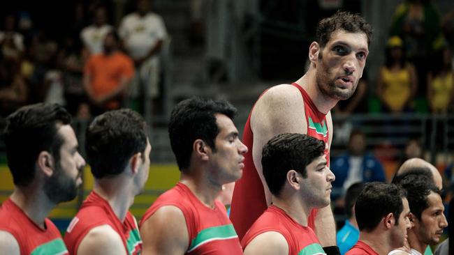 Iran's tallest sitting volleyball player Morteza Mehrzadselakjani stands with teammates before a preliminary match agasint Ukraine. Picture: AFP Photo/Yasuyoshi Chiba