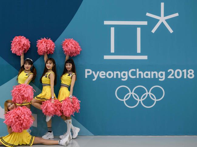 Cheerleaders pose for photo at the Gangneung ice hockey venue of the Pyeongchang Winter Olympics in Gangneung on February 17, 2018. / AFP PHOTO / Ed JONES