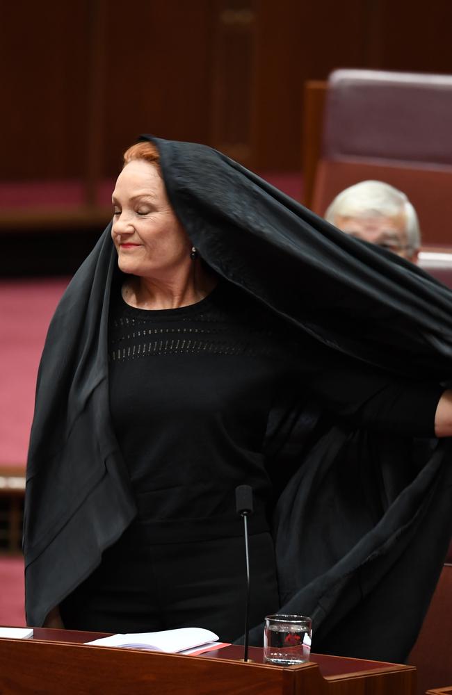 The One Nation leader took her time in removing the burqa during Senate Question Time. Picture: AAP