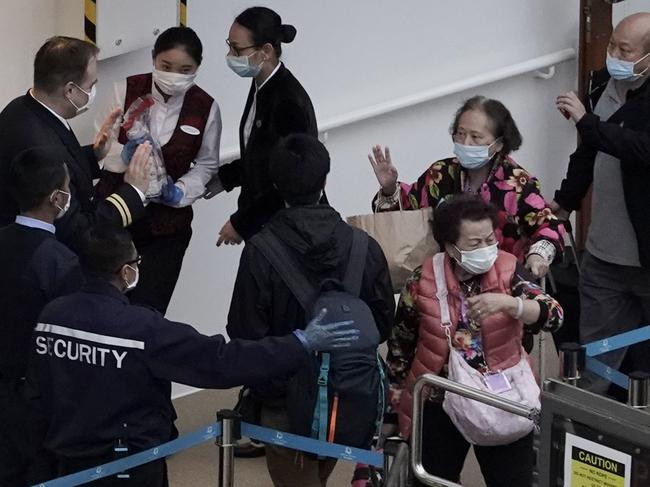 Passengers from the cruise ship World Dream docked in Hong Kong leave the ship after five days of being quarantined. Picture: AP