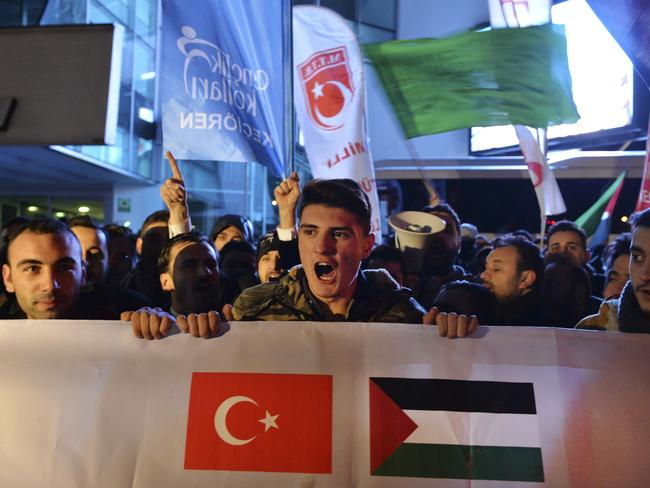 Holding a banner with a Turkish and a Palestinian flag, protesters chant anti-American slogans during a demonstration near the US embassy in Ankara, Turkey. Picture: AP Photo