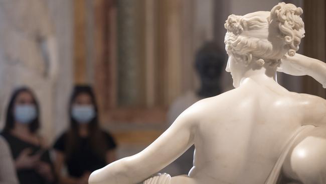 Women wearing masks walk past the sculpture Pauline Bonaparte as Venus Victrix at the Galleria Borghese in Rome on Thursday. Picture: AP