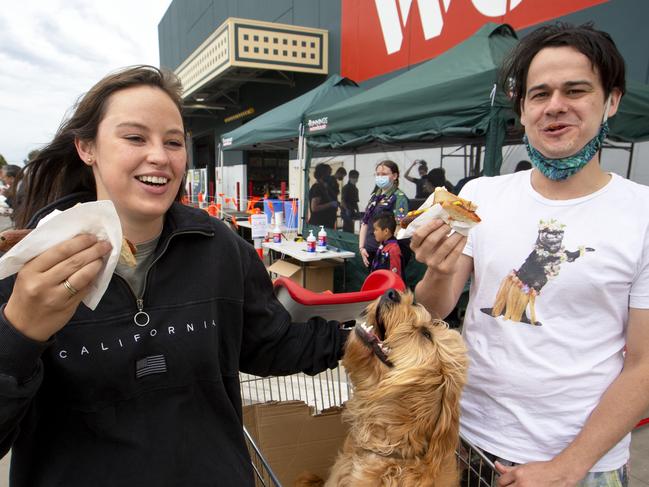 MELBOURNE, AUSTRALIA - NewsWire Photos December 5 2020: Jenn Isles and Dom Brown get a sausage with their dog Ted at Bunnings in Maribyrnong on Saturday morning  as the Bunnings sausage sizzle is finally making a return in Melbourne after an eight-month absence. Picture: NCA NewsWire / David Geraghty