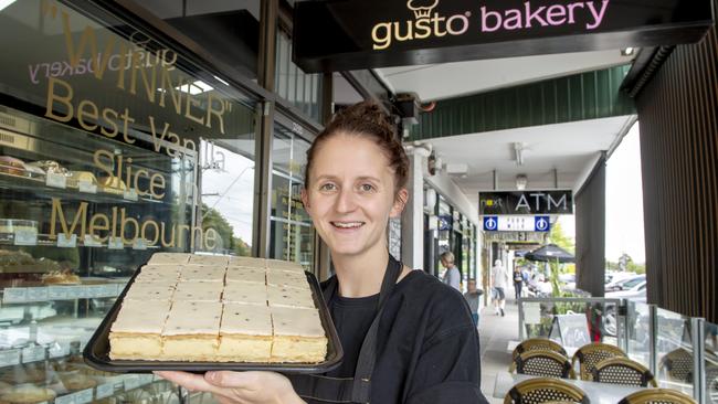 Mr Gray’s daughter Caitlyn Gray with the special edition passionfruit vanilla slice. Picture: Andy Brownbill