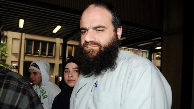 Bilal Khazal (right, wearing white) arrives at the NSW Supreme Court, Sydney. Previously convicted on terrorism offences in 2008 for producing a terrorism handbook, Khazal had his bail conditions heard today after the High Court upheld a crown appeal to serve his prior sentence of 9 years in prison. Khazal had his bail revoked and was taken in to custody a short time later.