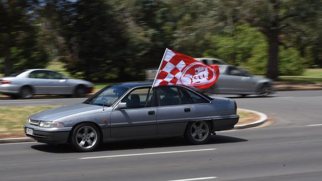 A Holden fan flies the flag on their Commodore at the closure of the Elizabeth plant. Picture: Bernard Humphreys