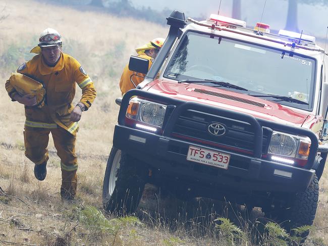 A member of the Lenah Valley Fire Brigade runs to the scene of an accident, in which a TFS 4x4 rolled, clutching a first aid kit. 2019 January Bushfires (Bush Fires). The fire which started in the Riveaux Road, Southwest region, which is now threatening Geeveston. Picture: RICHARD JUPE