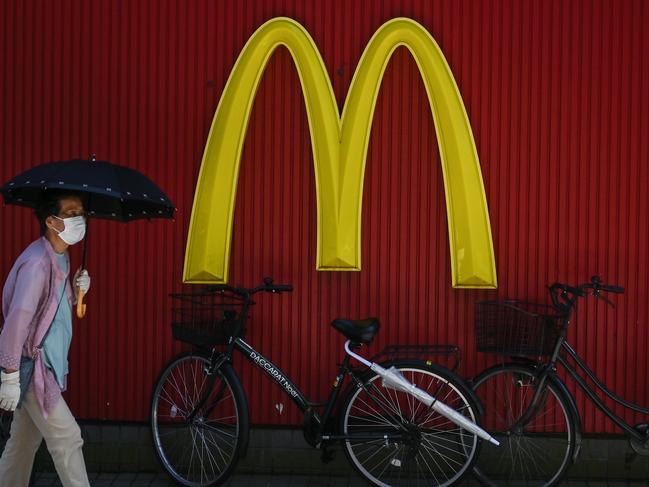 People walk past a McDonald's logo in Tokyo on July 19, 2020. (Photo by Charly TRIBALLEAU / AFP)