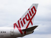 SYDNEY, AUSTRALIA - JANUARY 20: The Virgin logo displayed on an aircraft tail at Sydney Airport on January 20, 2024 in Sydney, Australia. Transport Minister Catherine King signed off on a deal that will allow Turkish Airlines to start serving the Australian market, rising to 35 flights a week by 2025. The decision came as the government was under mounting criticism from many for a perception that it was protecting the profits of Qantas and stymying competition in the market by limiting additional capacity for other carriers, such as Qatar Airways. (Photo by Jenny Evans/Getty Images)