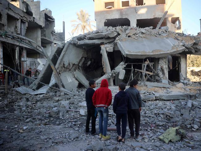 TOPSHOT - Palestinian children stare at a building destroyed in an Israeli airstrike in Nuseirat in the central Gaza Strip on December 1, 2024, amid the ongoing war between Israel and Hamas militants. (Photo by Eyad BABA / AFP)