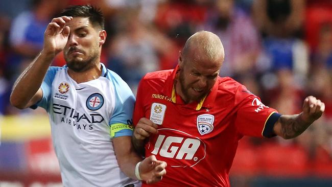 Adelaide United’s Taylor Regan takes a typically wholehearted approach to dealing with Melbourne City’s Bruno Fornaroli. Picture: Morne de Klerk (Getty Images)