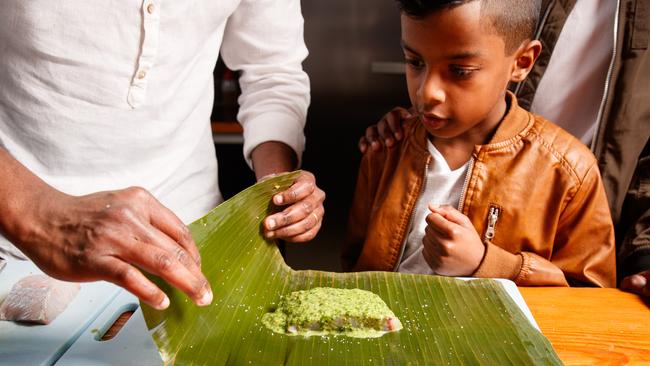 Sashi with son Ryan, 10, cooks up steamed barramundi. Picture: Matt Turner