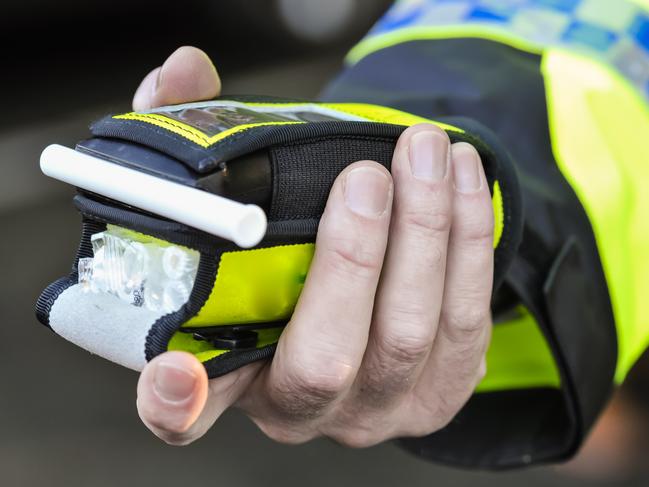 Belfast, Northern Ireland. 24 Nov 2016 - A police officer holds a roadside breathalyser alcohol breath test after taking a sample from a driver.