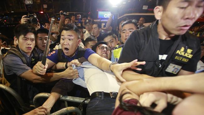 Protesters scuffle with police officers as thousands of people march in a Hong Kong street on Sunday. Picture: Kin Cheung/AP