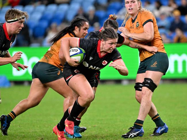 Canada's DaLeaka Menin (C) avoids a tackle by the Wallaroos defence. Picture: AFP