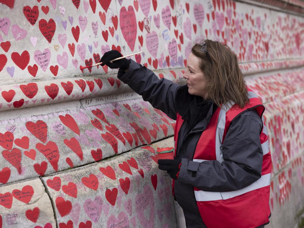 A woman adds hearts to the National Covid Memorial Wall near St Thomas' Hospital in London, England. By the New Year, one in 10 NHS staff were off work with 50,000 at home sick or self-isolating. Picture:vGetty Images